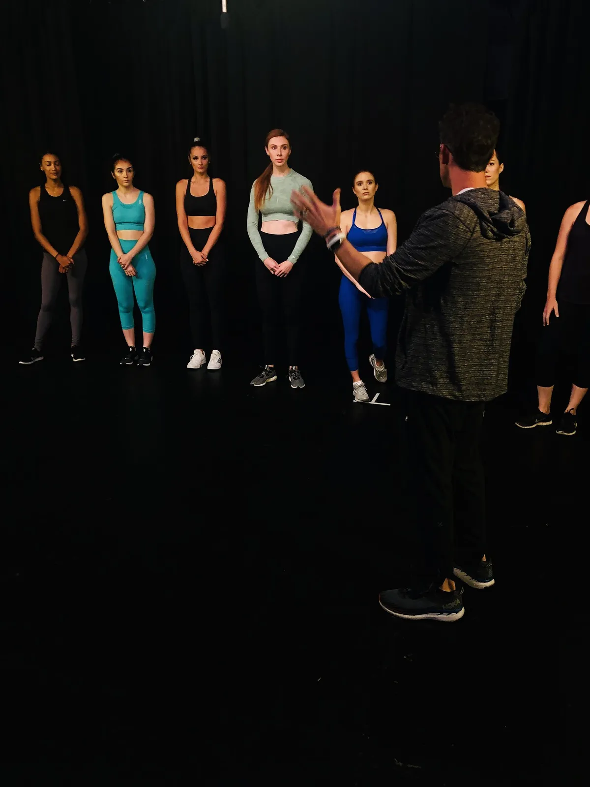 Matthew Dearing directing a line of five actors on the black stage at a Phoenix Casting session